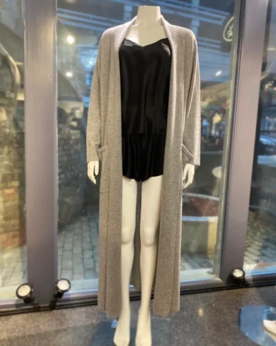 cashmere robe Gray cashmere robe draped over a mannequin wearing a black chemise, displayed in a boutique setting with soft lighting to emphasize the robe’s cozy texture and elegant style.